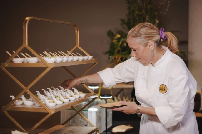 Professional Puerto Rican Chef Marisoll serving gourmet tastings on spoons during a high-end catering event.